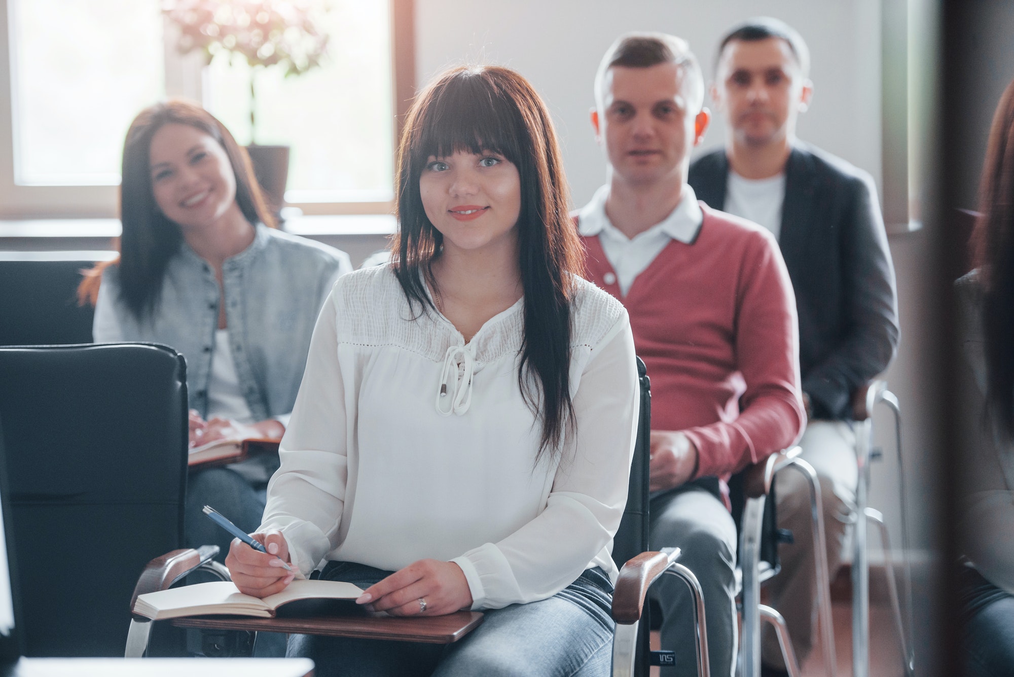 Group of people at business conference in modern classroom at daytime